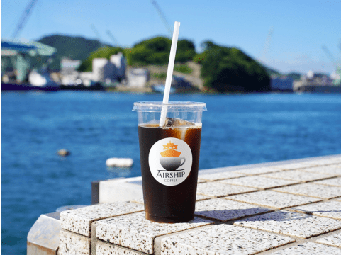 写真:海を背景にアイスコーヒーが置いてある